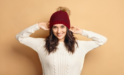 Woman wearing a Red sweater-knit hat with a white sweater